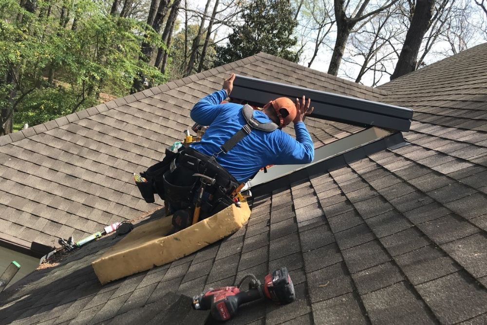 A man working on a roof to install a skylight, representing our skylight replacement and repair services in San Diego, CA.
