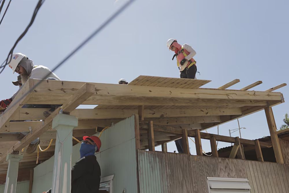 Three workers on a roof, emphasizing our emergency roofing service offered in San Diego, CA.